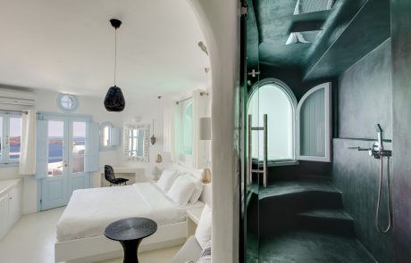 The interior of a bright Dana Villas suite and views from its private black stone bathroom