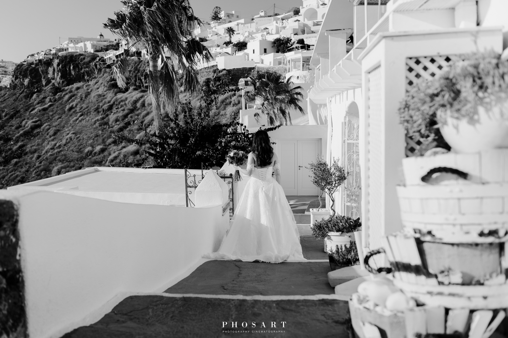 Α bride walking in the alleys of the caldera, Santorini, in black and white photo