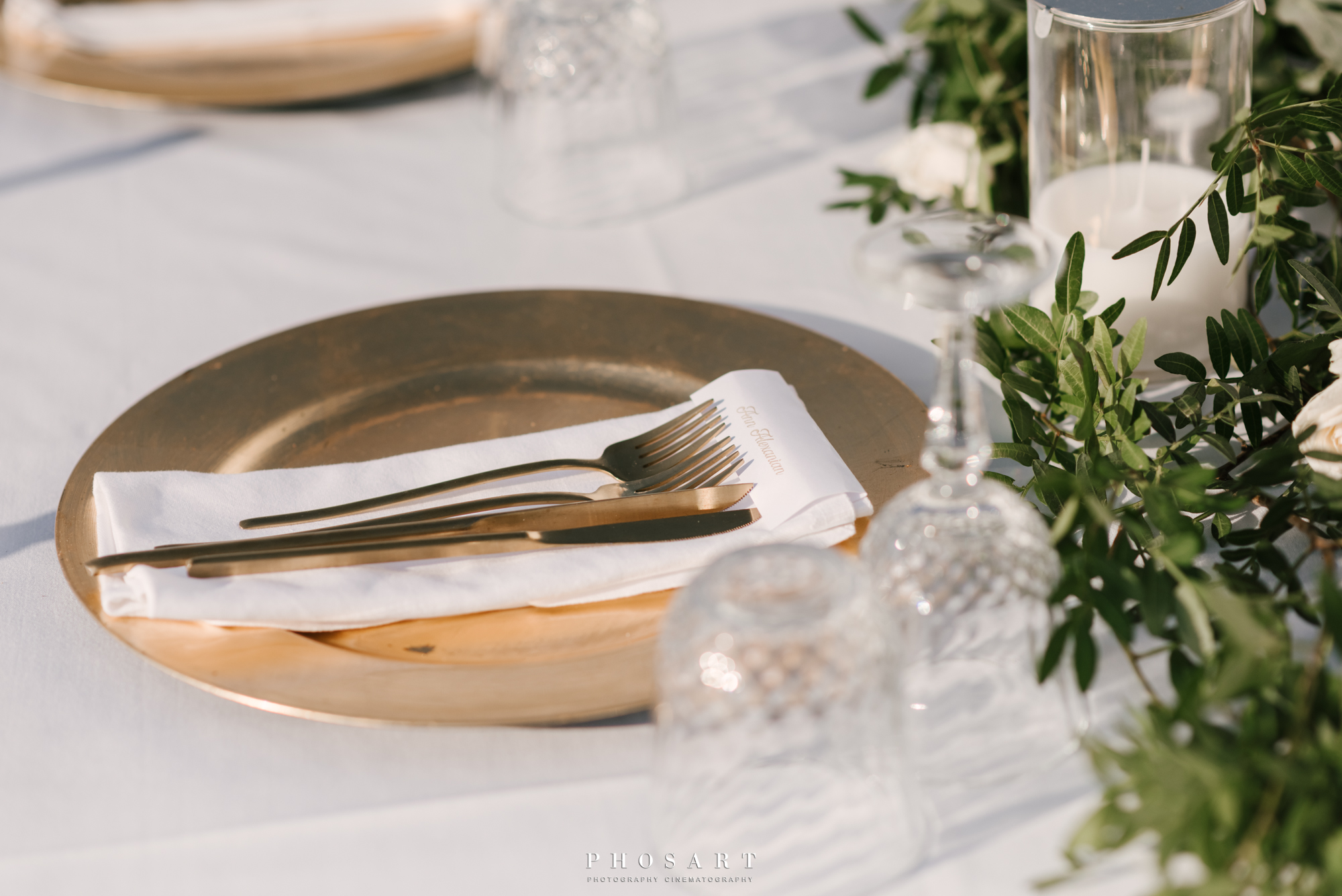 Gold plate, gold cutlery and two crystal glasses on a bridal table