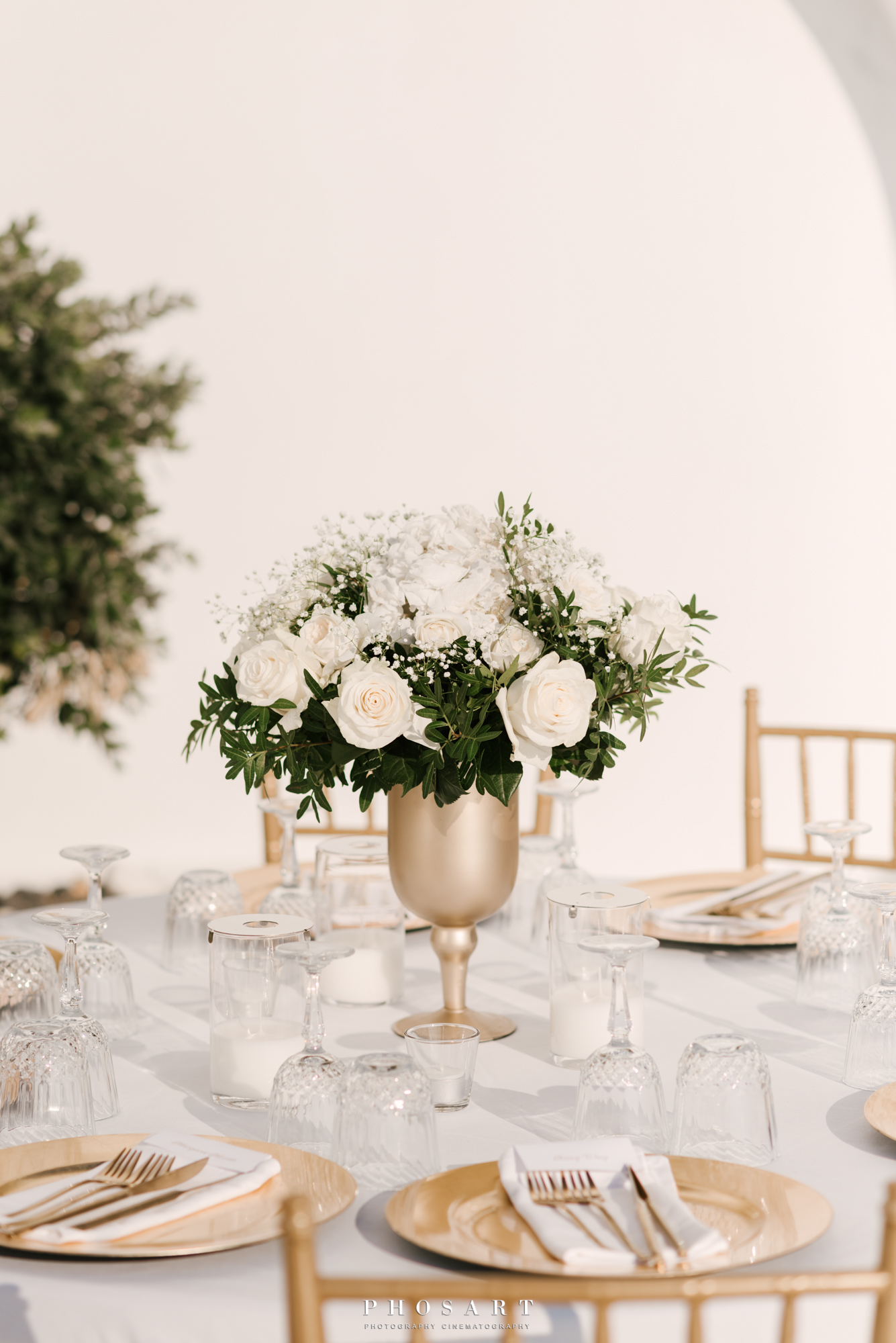 An elegant wedding rotunda decorated with gold plates and a bouquet of white roses