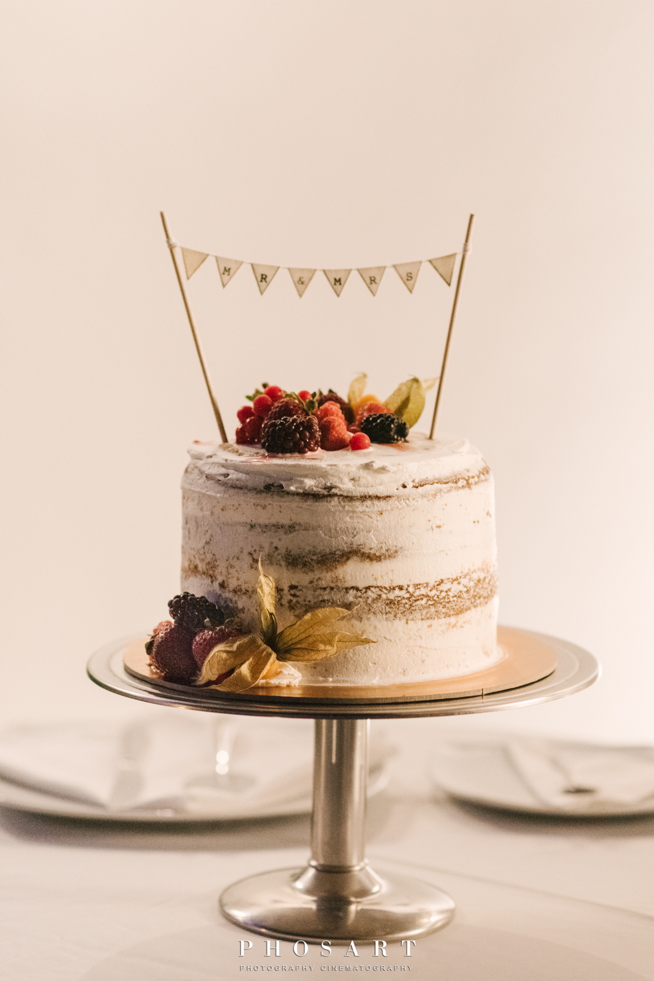 A multilayer wedding cake with cream, strawberries and raspberries