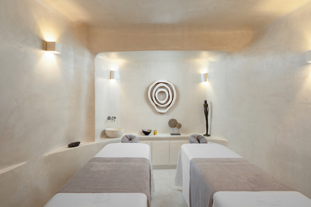 The interior of the massage room at Soma Spa with two separate beds, stone walls and minimalist décor