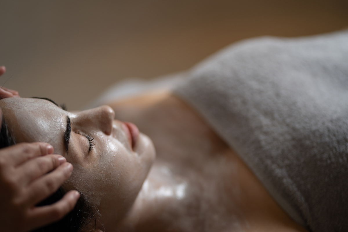 Woman relaxes and enjoys a face beauty treatment in Dana Villas Santorini Soma Spa